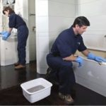 Man and woman cleaning a bathroom