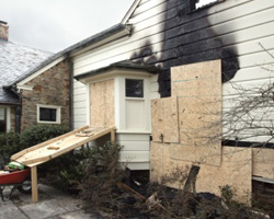 A home’s boarded up exterior before fire damage restoration