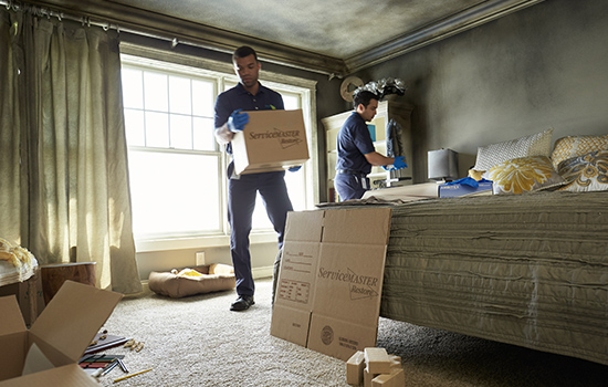 ServiceMaster experts packing up a fire-damaged room during fire and smoke damage restoration