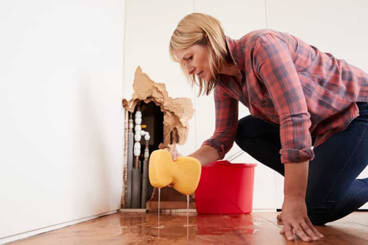 Woman cleaning up water damage with a sponge